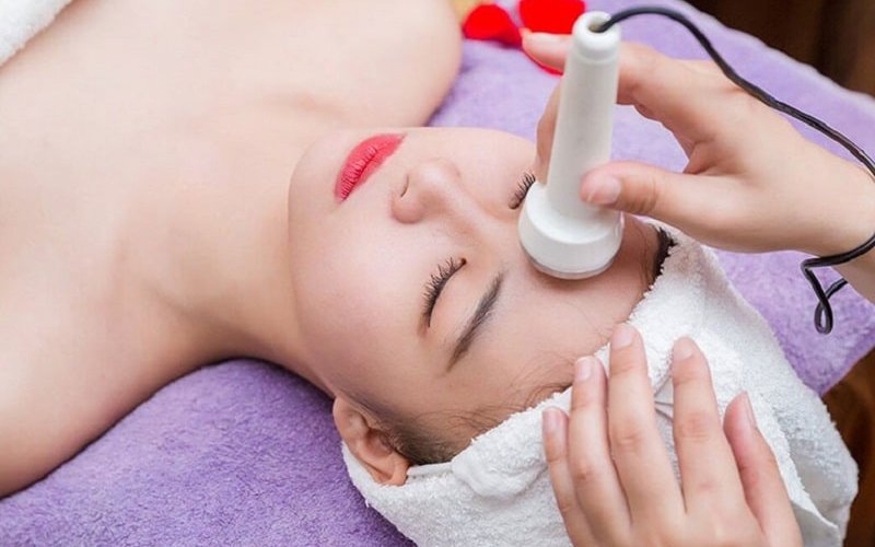 Kỹ thuật viên tiếp tục thoa tinh chất điều trị mụn.